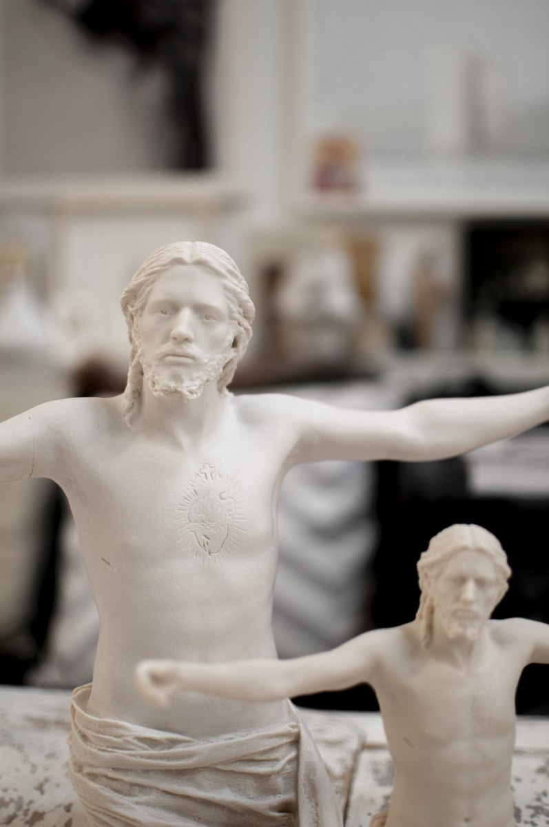 Esculturas del Sagrado Corazón de Jesús con los brazos abiertos, en el interior del estudio.