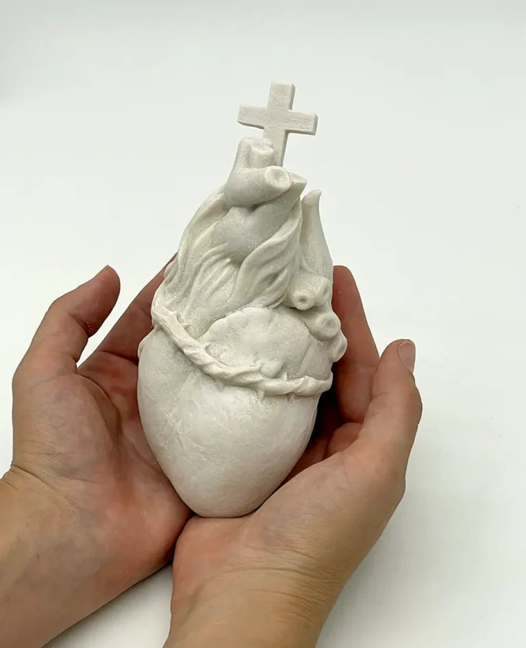 Escultura del Corazón de Jesús sostenida entre las manos