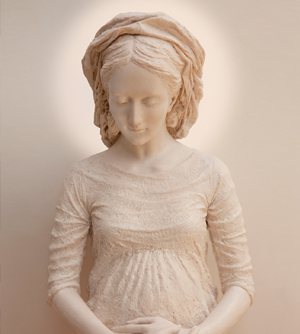 Nuestra Señora de Hakuna, embarazada y con las manos sobre el vientre, ante un fondo cálido.