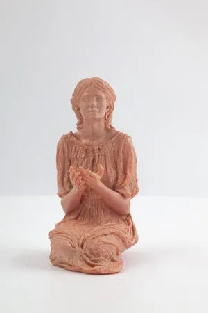 La talla completa de Nuestra Señora de Alegra, en terracota, arrodillada con las manos recogidas sobre fondo claro.
