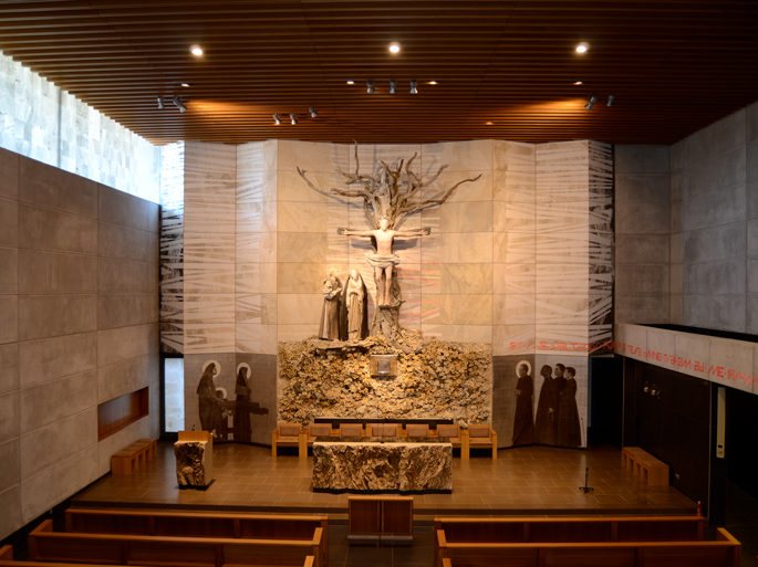 Vista general del Oratorio de Bidasoa: el retablo en forma de T con el Calvario en el árbol de la Cruz, el altar y los bancos.
