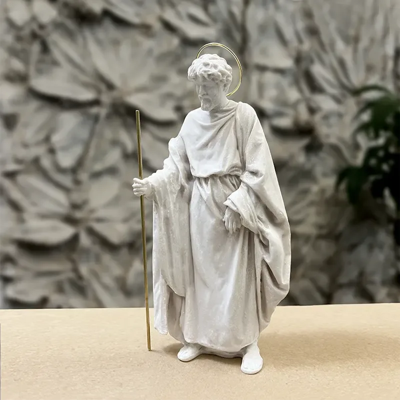 San José en pie, con su vara dorada y la aureola, ante un relieve de hojas.