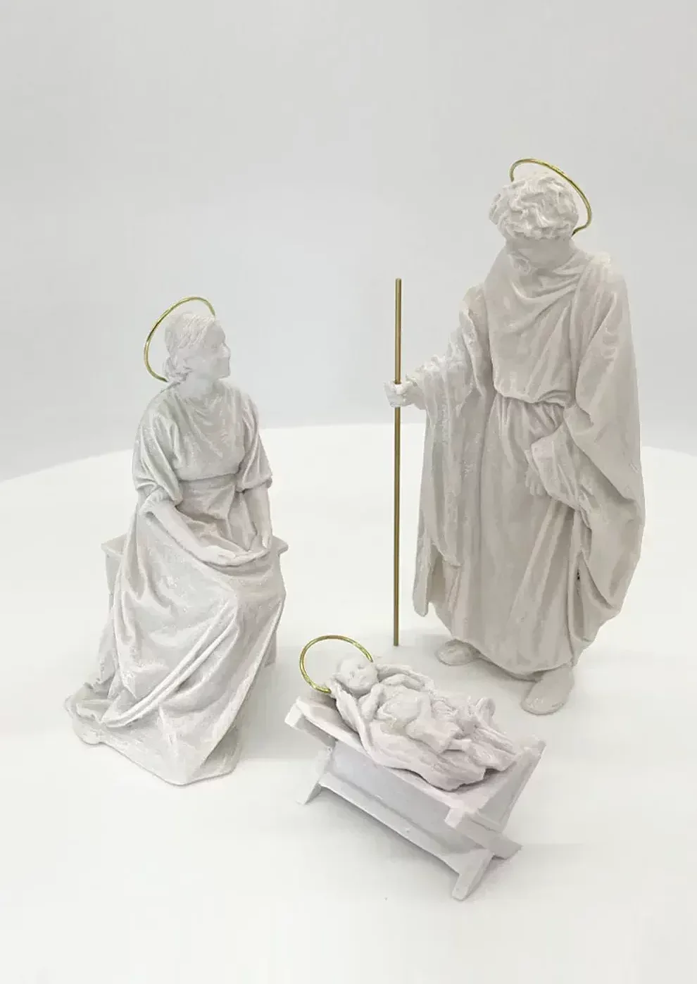 La Sagrada Familia vista desde arriba: María sentada, San José en pie con su vara y el Niño en el pesebre.