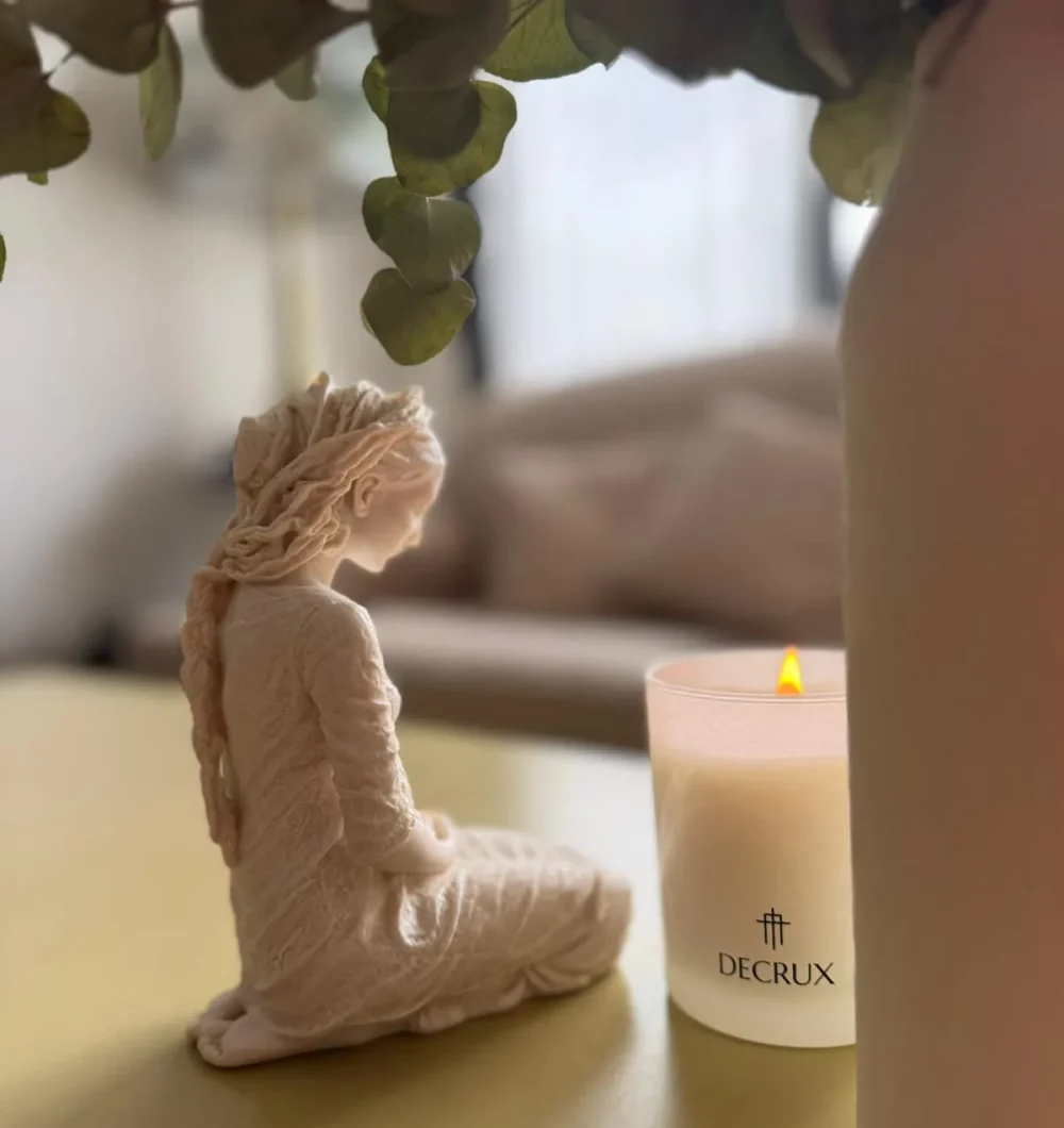 Una madre junto a una escultura devocional en su rincón de la casa