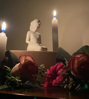La miniatura de la Virgen entre dos velas encendidas y unas rosas.