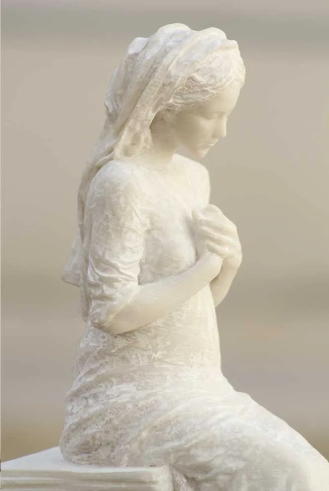 La Bella Pastora, en alabastro, sentada con las manos recogidas sobre el pecho.